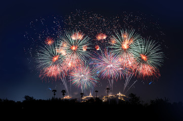 Firework display festival ..The most famous firework Pra Nakorn Kiri festival in petchaburi Thailand with palm tree silhouette in foreground and three pagodas on the hill in background.