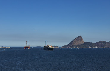 Fototapeta premium Wonderful city, Rio de Janeiro and the Sugar Loaf mountain in the background, Brazil, South America. Oil and gas ship. Offshore oil industry. Copy space for advertising, to insert text or slogan.