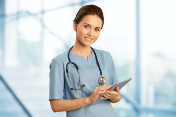 Attractive young female doctor with blurred hospital interior on