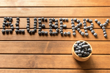 The inscription of blueberries from fresh berries on a wooden table. The concept of natural food