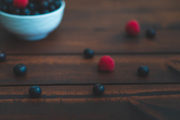 Fresh berries in a bowl on a dark brown wooden table