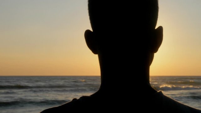 Missing home,refugee.Pensive young african man looking at sunset- slow motion
