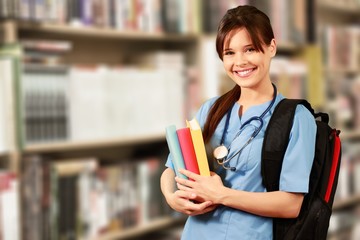 Attractive young female doctor student on background