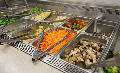 variety of colorful fresh vegetable salad in container in restaurant