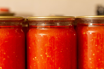 Homemade tomato juice, sauce in glass jars. Closeup, selective focus
