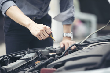 Businessmen help businesswomen check and repair broken cars