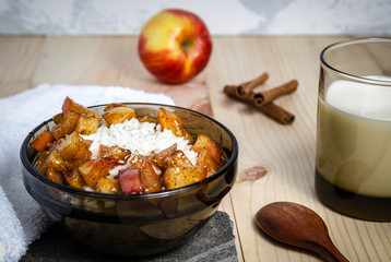 Rice porridge with milk and caramelized cinnamon vanilla apples in bowl. Breakfast concept. Close up.