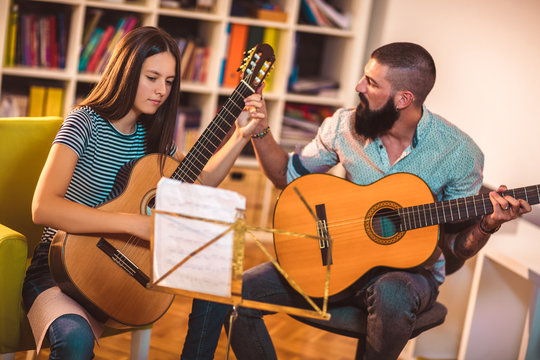 Guitar teacher teaching the girl at home.