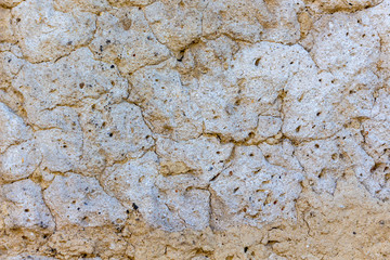 The texture of old plaster with cracks, light beige color_