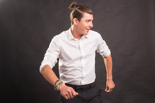Dancing, happiness, people concept - handsome man in white shirt dancing over the grey background