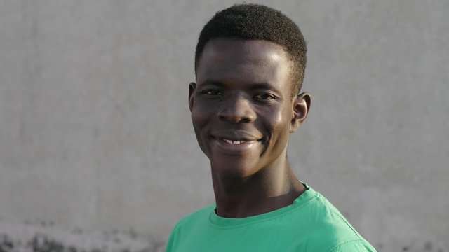 Relaxed young american black man turning and smiling at camera- outdoor