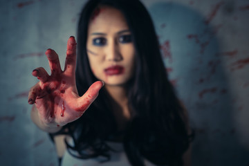 Asian woman's hands are bloody red in dark background, Concept of murder and crime