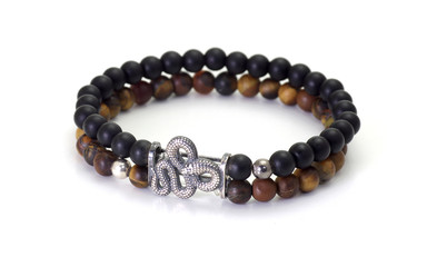 Unpolished tiger's eye and black onyx gemstone bracelet with silver snake figurine, isolated on white background