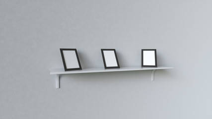 Blank white photo frames standing on shelf