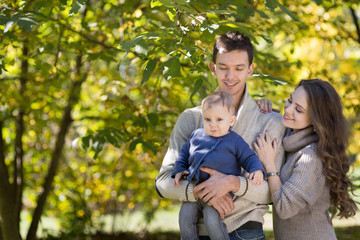 Naklejka na ściany i meble family with a baby in autumn park