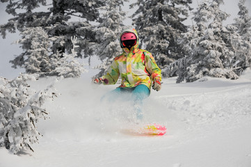 Fototapeta na wymiar Girl running down the mountain slope on the snowboard