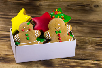 Tasty Christmas gingerbread cookies in box on wooden table