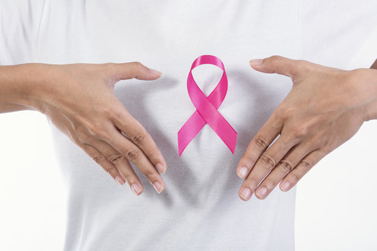 Woman in white t-shirt with pink ribbon on chest. supporting symbol of breast cancer awareness and international women day campaign.