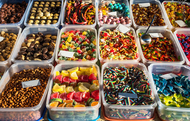 Different sweets in boxes at at the market with empty postcard for text. Boxes with candies at the market.