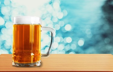 Mug of cold beer with foam, close-up