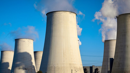 Obraz premium Smoking chimneys against the blue sky, environmental pollution concept.