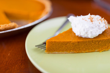 Slice of pumpkin pie with whipped cream