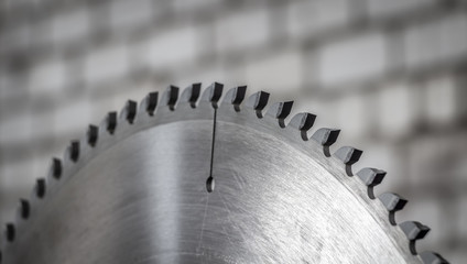 Circular saw against a gray brick wall.