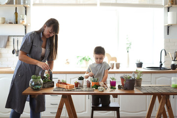 mother and son transplant plants at table