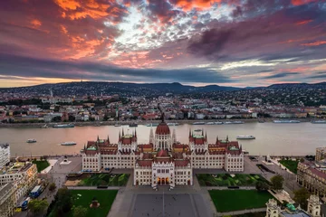 Zelfklevend Fotobehang Budapest, Hungary - Aerial panoramic view of the Parliament of Hungary at sunset with beautiful dramatic purple clouds and sightseeing boats on River Danube © zgphotography