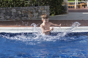 little boy plaiyng in swimming pool