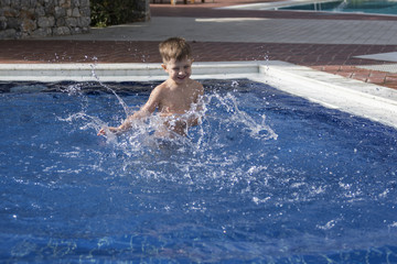 little boy plaiyng in swimming pool