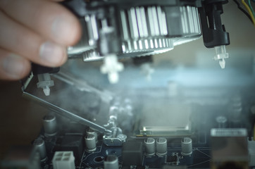 Computer technician engineer is installing a CPU fan cooling system on the computer motherboard.