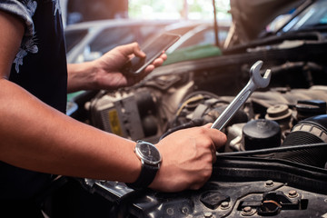 Handyman services  holding a screwdriver and Search for information from mobile phones.