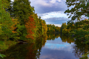 Fototapeta na wymiar Peaceful calm autumn pond with colorful reflection