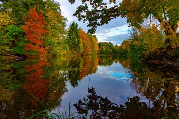 Peaceful calm autumn pond with colorful reflection