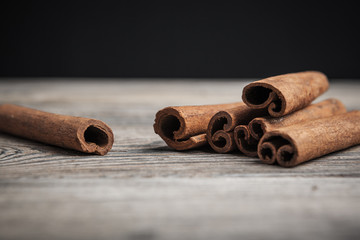 Cinnamon sticks on wooden background.