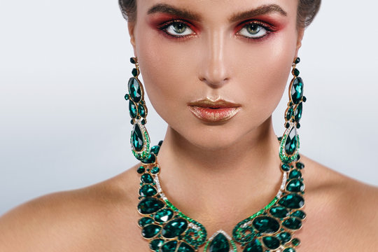 Sexy woman wearing big beautiful necklace and earrings with a lot of gems