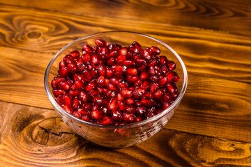 Seeds of the garnet fruit in glass bowl on wooden table