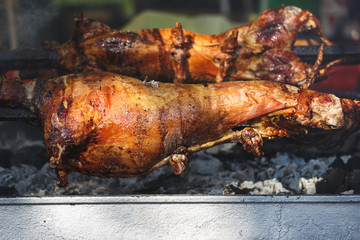 Crispy whole roasted lamb on barbecue spit , selective focus