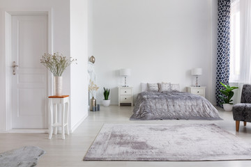 Elegant new york style bedroom with comfortable bed, real photo with copy space on the white wall