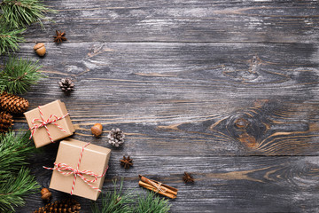 Christmas gifts in rustic stlye. Two gift boxes with cinnamon sticks, pine cones, anise stars and...