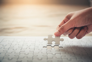 Female Hand is Putting Last Piece Jigsaw Puzzle to Complete Mission, Close-Up of Woman Hand...