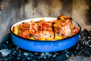 Preparing and cooking pork roast in traditional metal pot Peka.