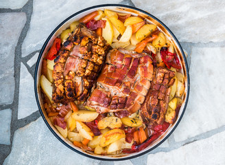 Preparing and cooking pork roast in traditional metal pot Peka.