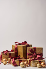 gift boxes with burgundy ribbons and golden christmas balls isolated on white