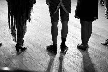 Legs of actors and dancers in costumes  standing on stage under the light of soffits and floodlights, in black and white © anch87189