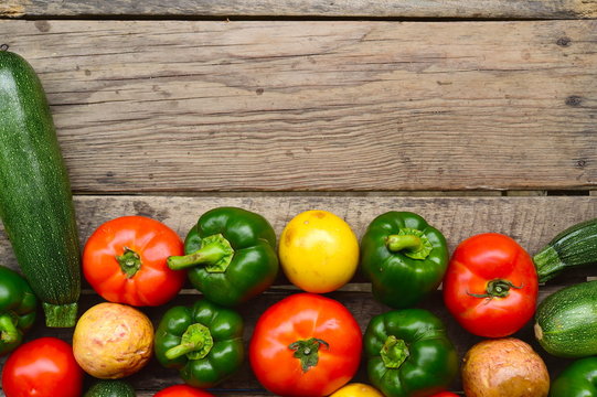 Cucumbers, tomatoes and sweet pepper on wooden table for background