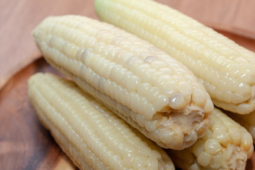 close up of waxy corn in wooden plate