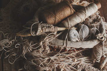 Needlework, macrame, knitting. Yarn and thread of natural colors in a wicker basket. Women's hobby.