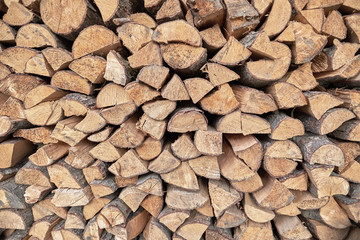 Firewood pile stacked chopped wood trunks for winter heating fireplace